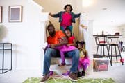 Syreeta Lazarus, 36, looks over her family while her husband, Tim Lazarus, helps his daughter put on her shoe in preparation for the park. Turner has suffered postpartum pre-eclampsia on three separate occasions after delivering her daughters.