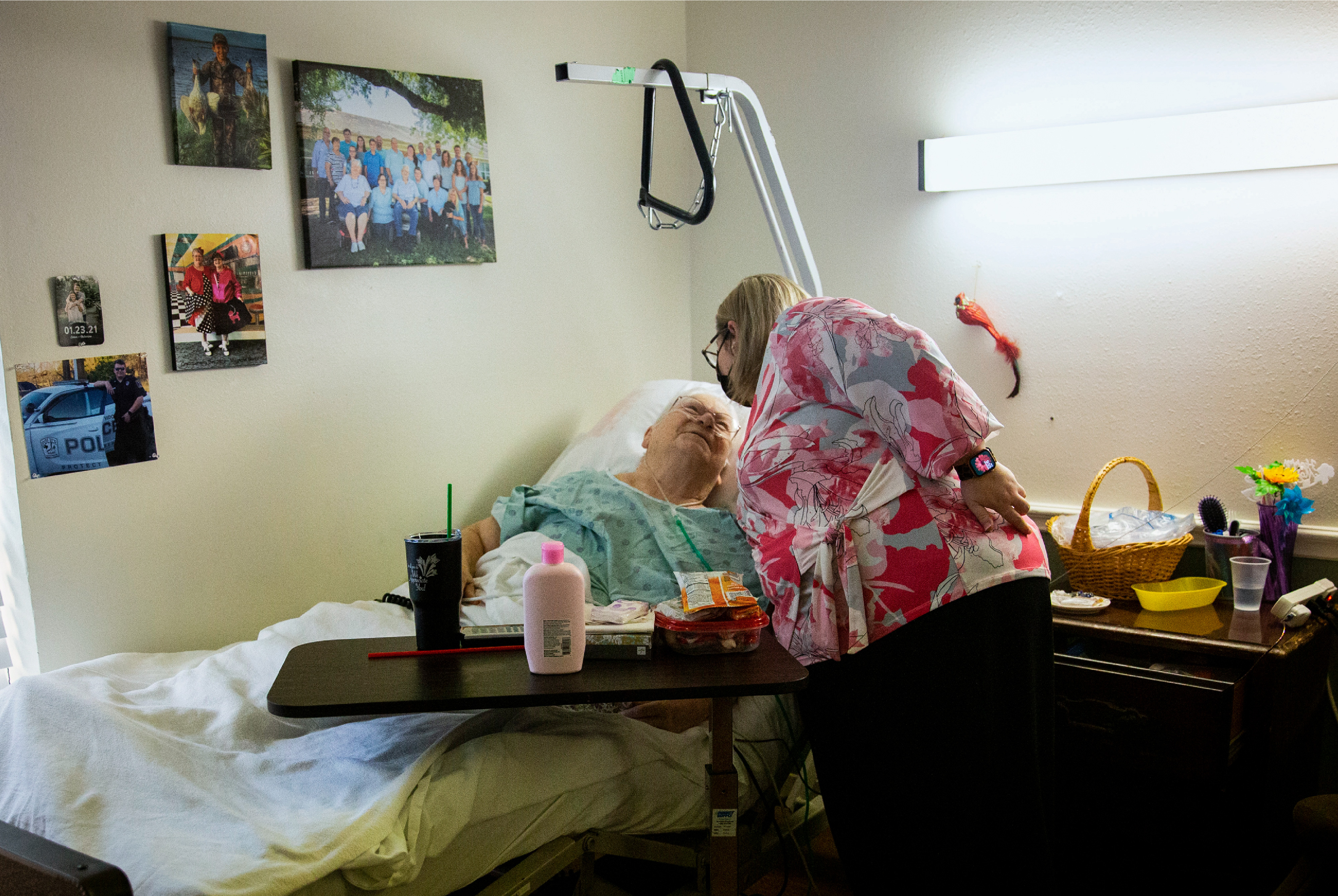 Photo of a woman bending down to hug a patient in a bed.