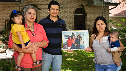 Angel Hurtado's widow, Victorina; his children, Christian and Karla; and his grandchildren pose with an old holiday photo. Photo by Callie Richmond.