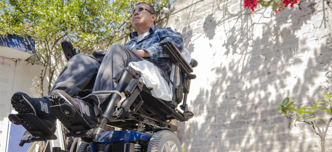 Santiago Arias in front of his Mexico City home. Arias is paralyzed from the chest down after a two-story fall from the roof of a warehouse at a Houston job site in 2006. Photo by Justin Dehn.